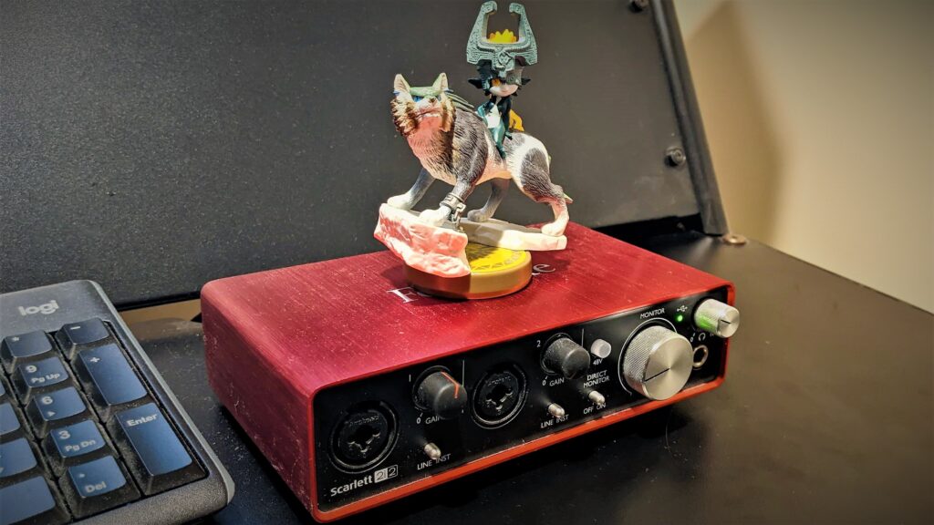 A Focusrite Scarlett 2i2 audio interface with a figurine from The Legend of Zelda.